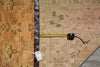 Load image into Gallery viewer, Measuring tape on a patterned rug with a visible brand tag.