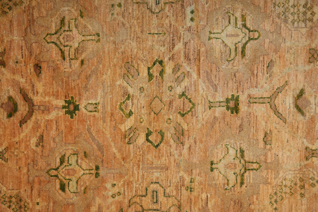 Close-up of a patterned rug with geometric designs on a warm-toned background