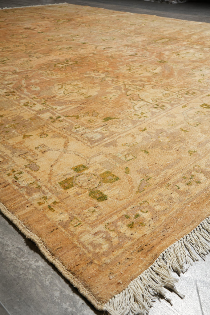 Beige patterned rug with tassels on a concrete floor