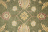 Load image into Gallery viewer, Close-up of a patterned rug with floral designs on a green background