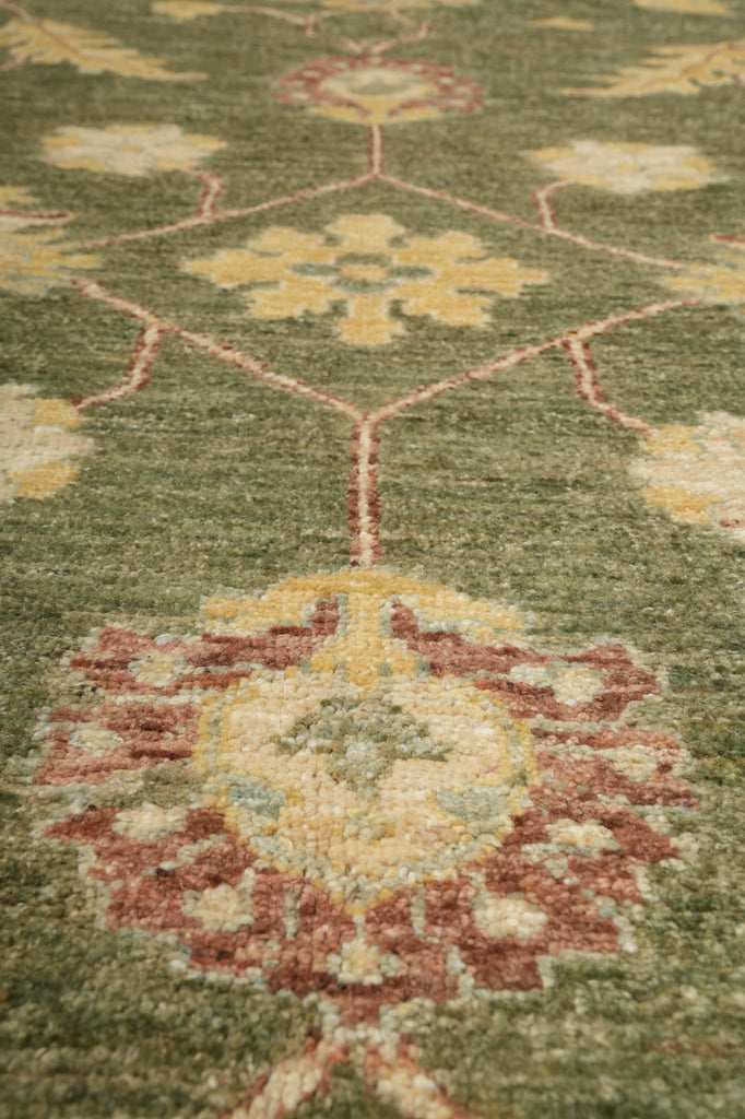 Close-up of a patterned green rug with intricate designs.