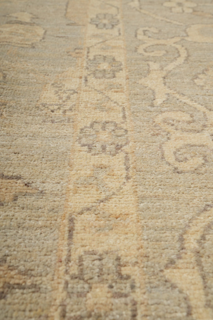 Close-up of a textured fabric with intricate patterns in beige and brown tones.