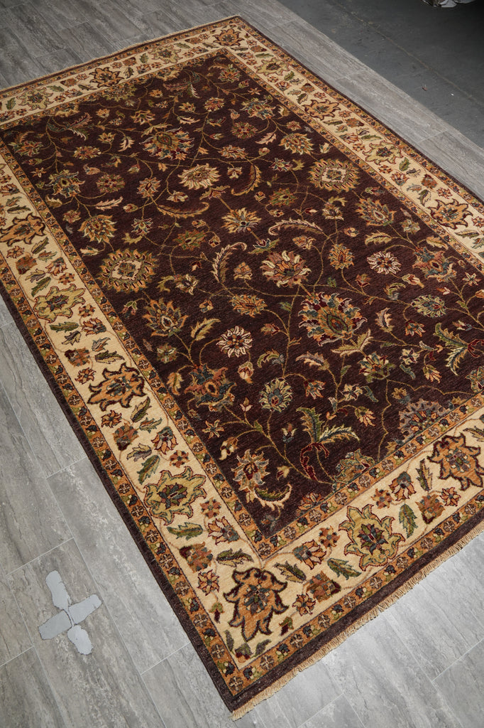 Decorative rug with intricate patterns on a gray floor.