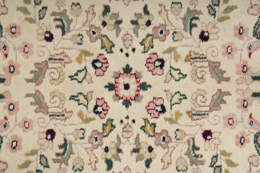 Close-up of a floral patterned rug with intricate details on a beige background.