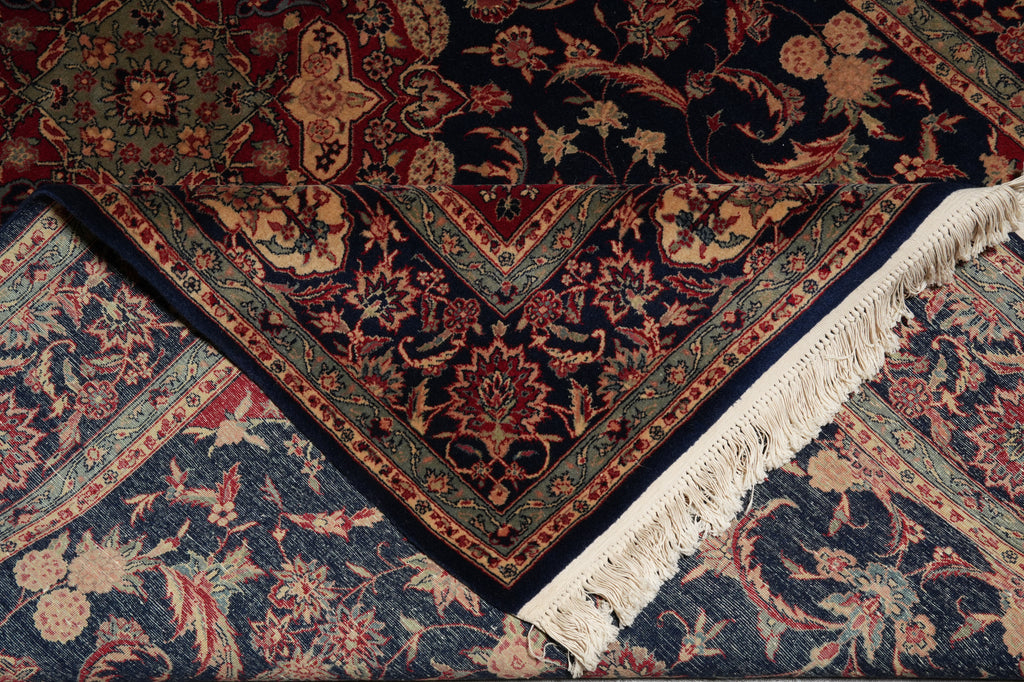 Close-up of a patterned rug with intricate designs and fringes.