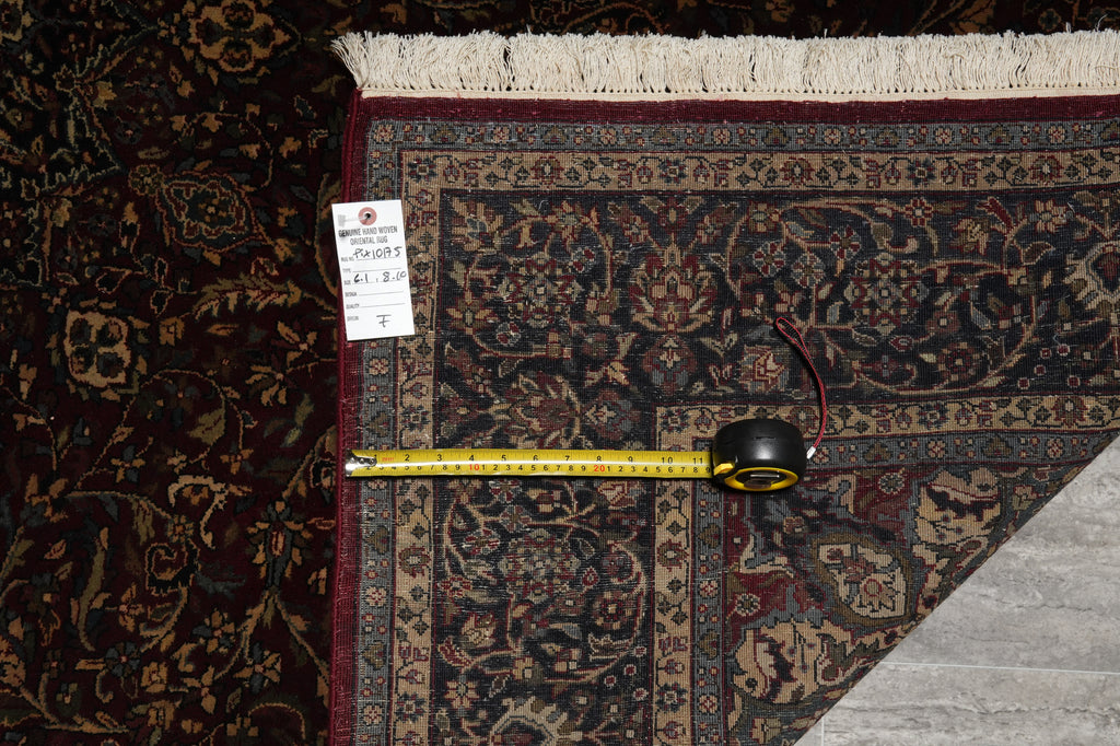 Patterned rug with a measuring tape and price tag on a dark surface