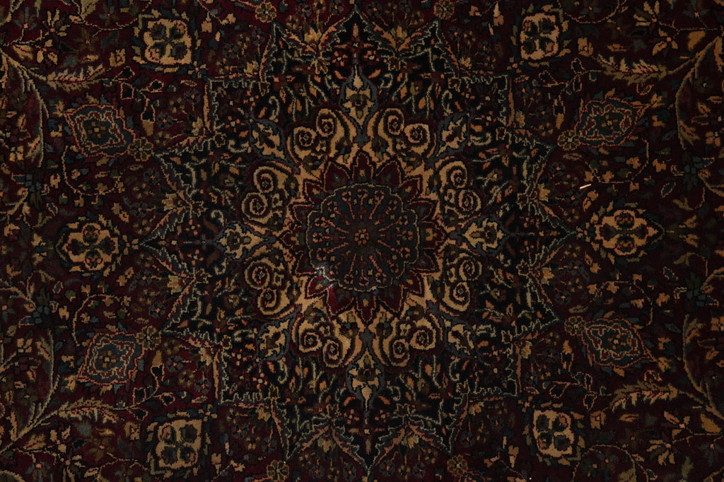 Close-up of a dark patterned rug with intricate designs.