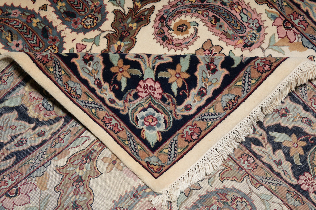 Close-up of a patterned rug with intricate designs and fringes.
