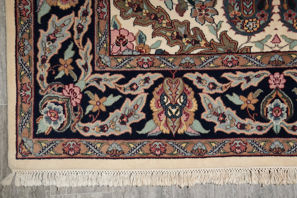 Close-up of a patterned rug with intricate designs on a gray floor.