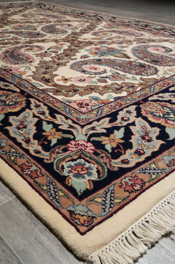 Close-up of a patterned rug with intricate designs on a gray floor.