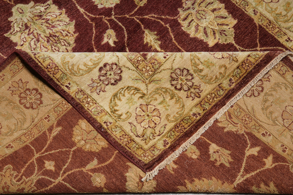 Close-up of a patterned rug with floral designs in brown and beige tones.