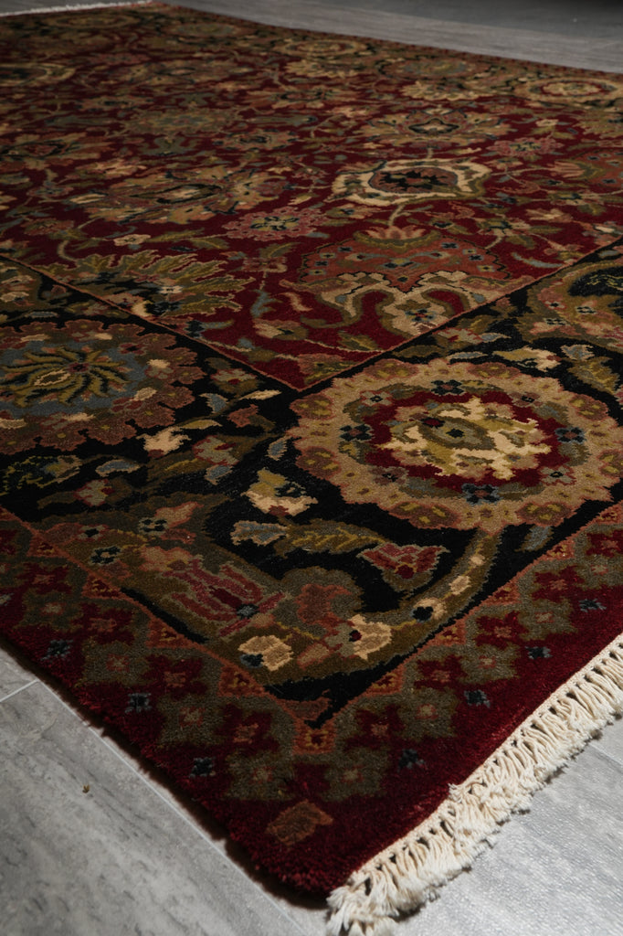 Close-up of a patterned rug with intricate designs on a light gray floor.