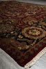 Load image into Gallery viewer, Close-up of a patterned rug with intricate designs on a light gray floor.