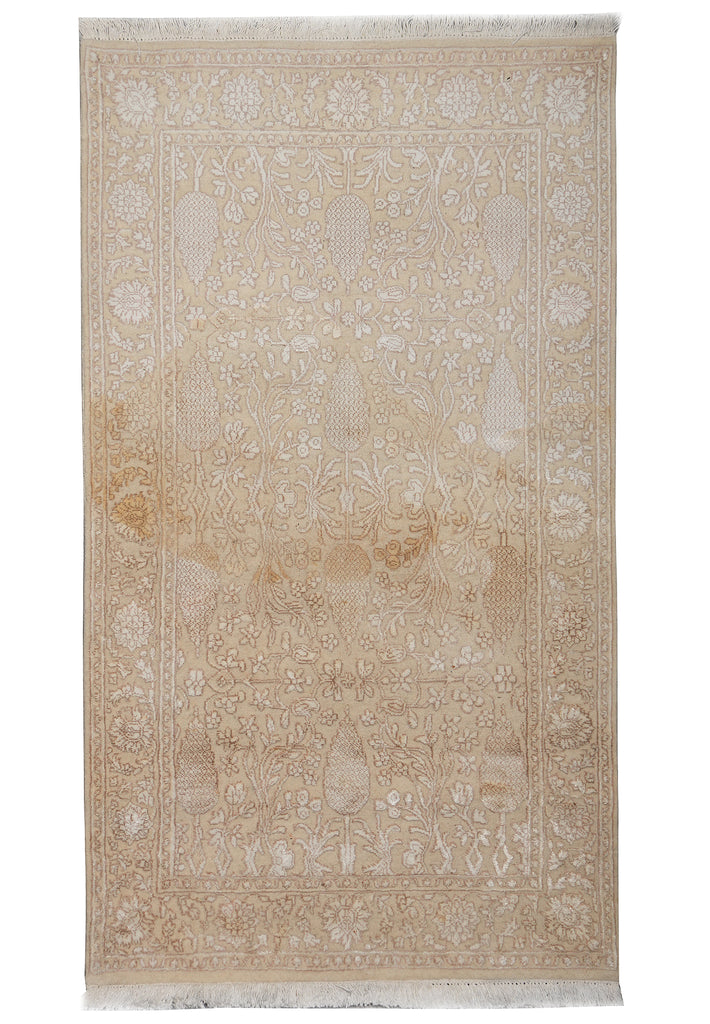 Beige and white patterned rug on a plain background