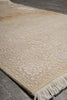 Load image into Gallery viewer, Beige patterned rug with tassels on a gray floor.