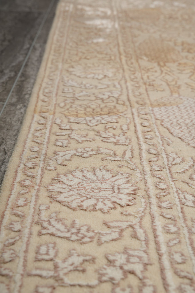 Close-up of a beige patterned rug with intricate designs.