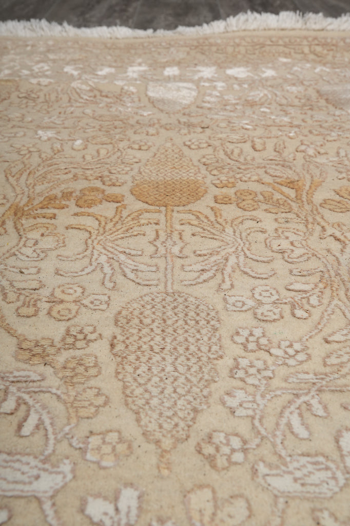 Close-up of a patterned rug with intricate designs on a beige background