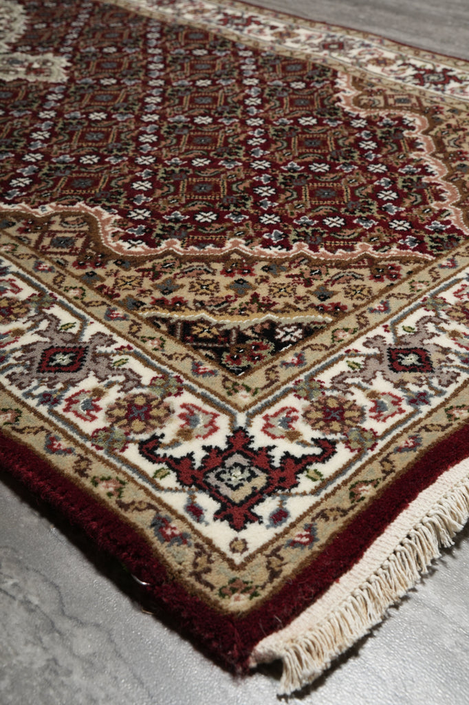 Close-up of a patterned rug with intricate designs on a plain background