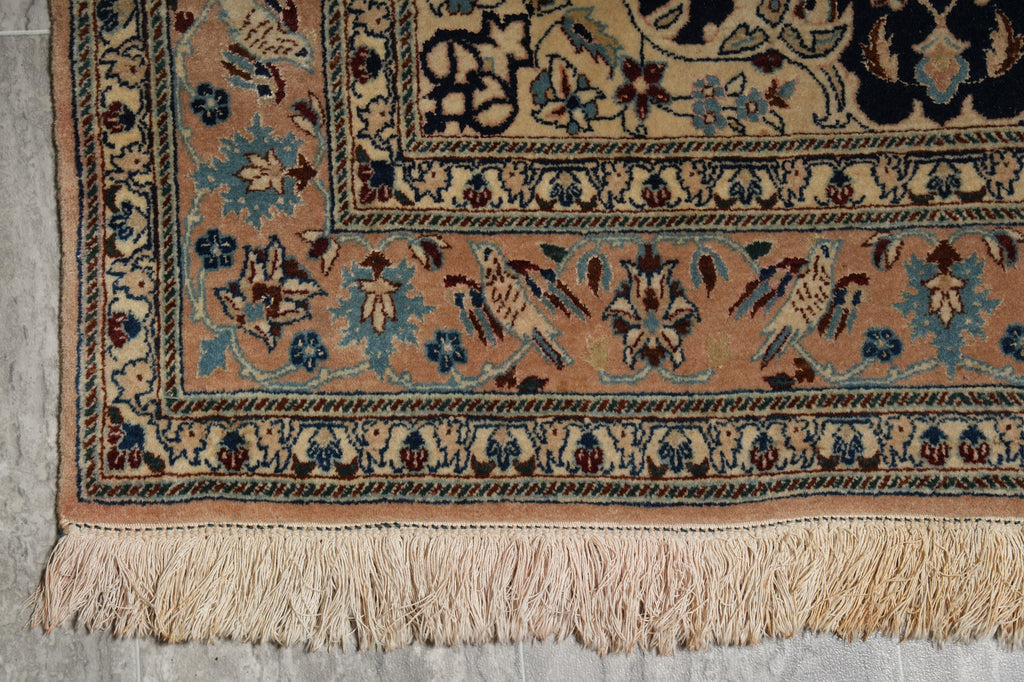 Close-up of a patterned rug with intricate designs on a concrete floor.