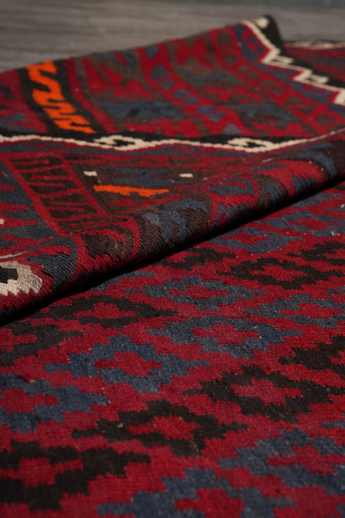 Close-up of a patterned fabric with red, blue, and black colors.