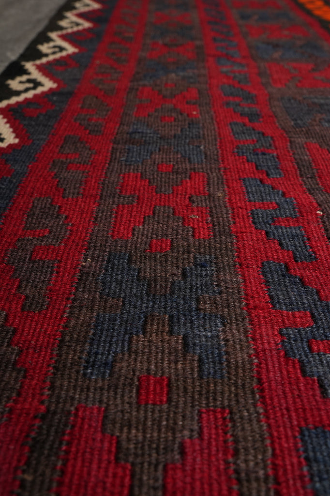 Close-up of a patterned rug with red and brown colors