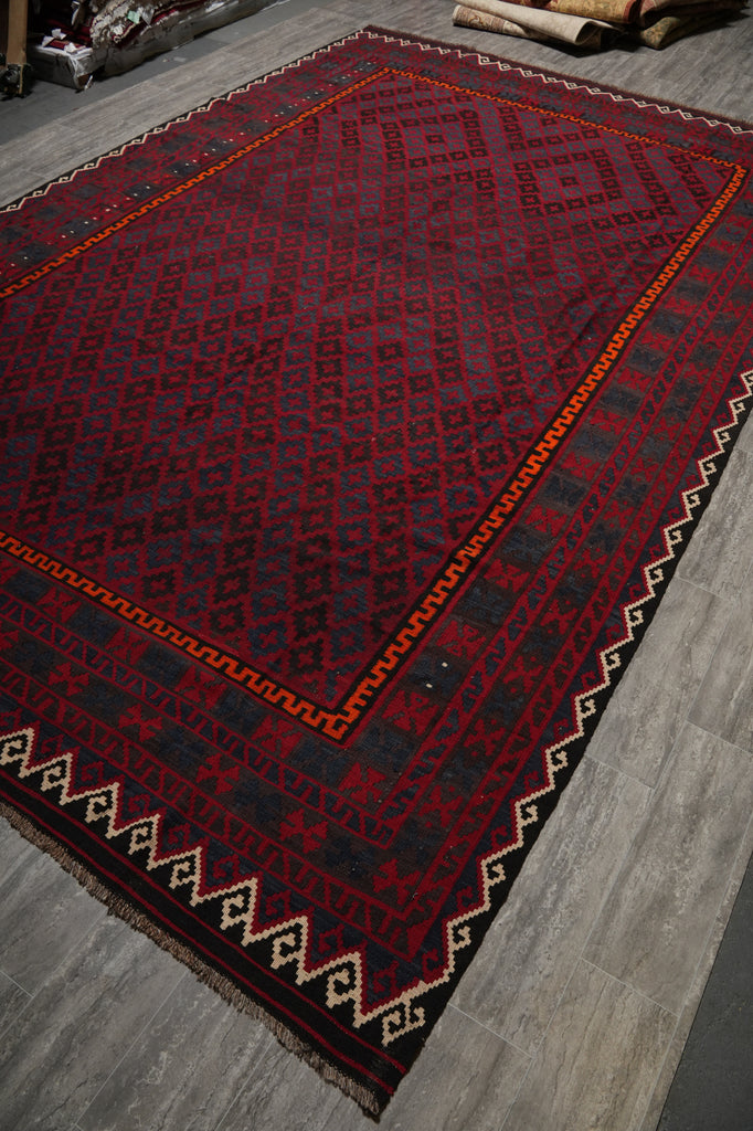 Hexagonal red and black patterned rug on a wooden floor
