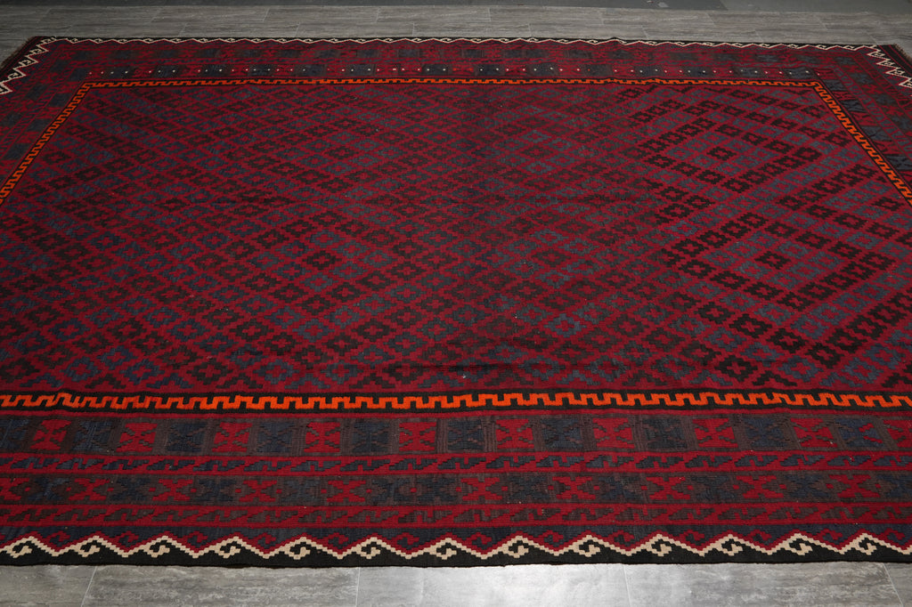 Red and black patterned rug on a wooden floor