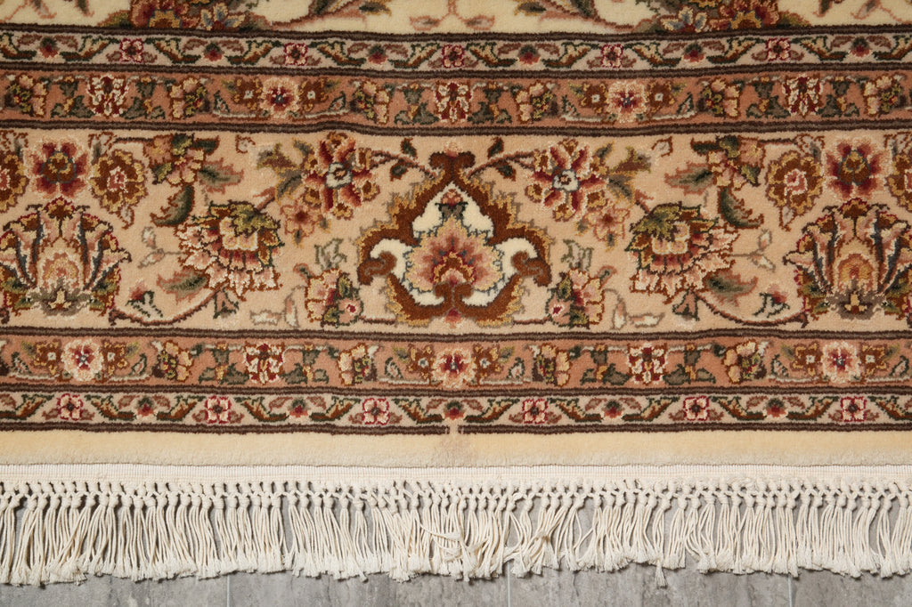 Close-up of a patterned rug with fringes on a neutral background