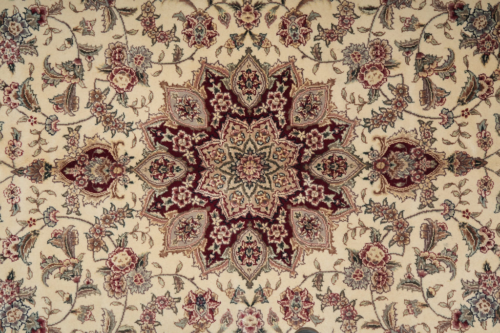 Close-up of a patterned rug with intricate designs on a beige background