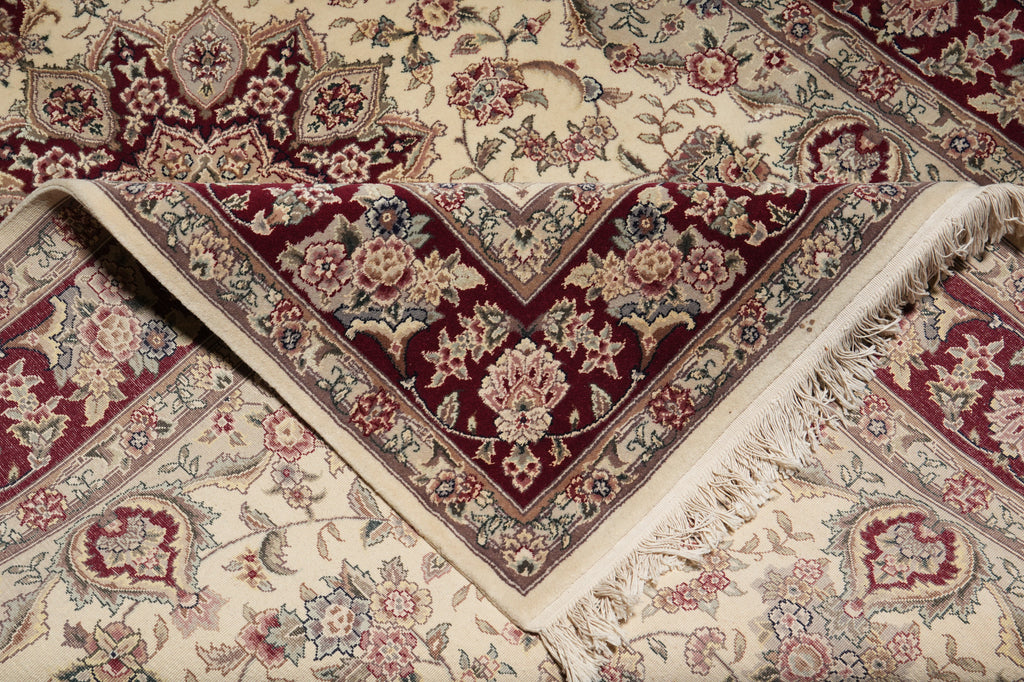 Close-up of an intricately patterned rug with red and beige colors.