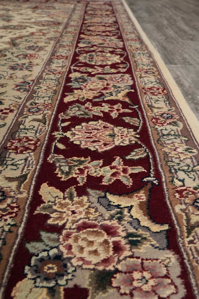 Close-up of a patterned rug with floral designs on a red background.