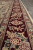Load image into Gallery viewer, Close-up of a patterned rug with floral designs on a red background.