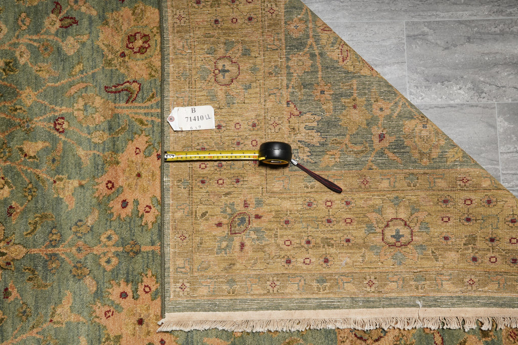 Decorative rug with a measuring tape on top, placed on a wooden floor.