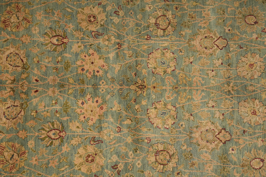 Close-up of a patterned rug with floral designs on a teal background