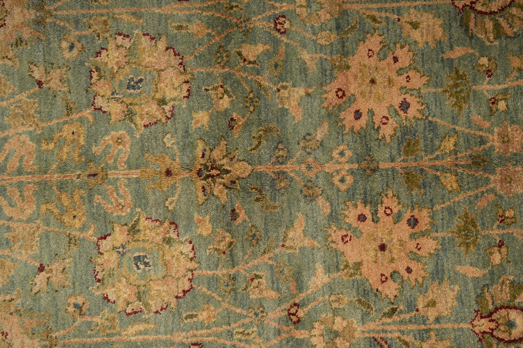 Close-up of a patterned rug with floral designs on a blue-green background