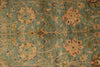 Load image into Gallery viewer, Close-up of a patterned rug with floral designs on a blue-green background