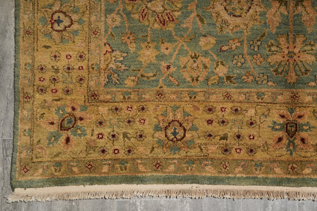 Close-up of a patterned rug with intricate designs on a gray floor.