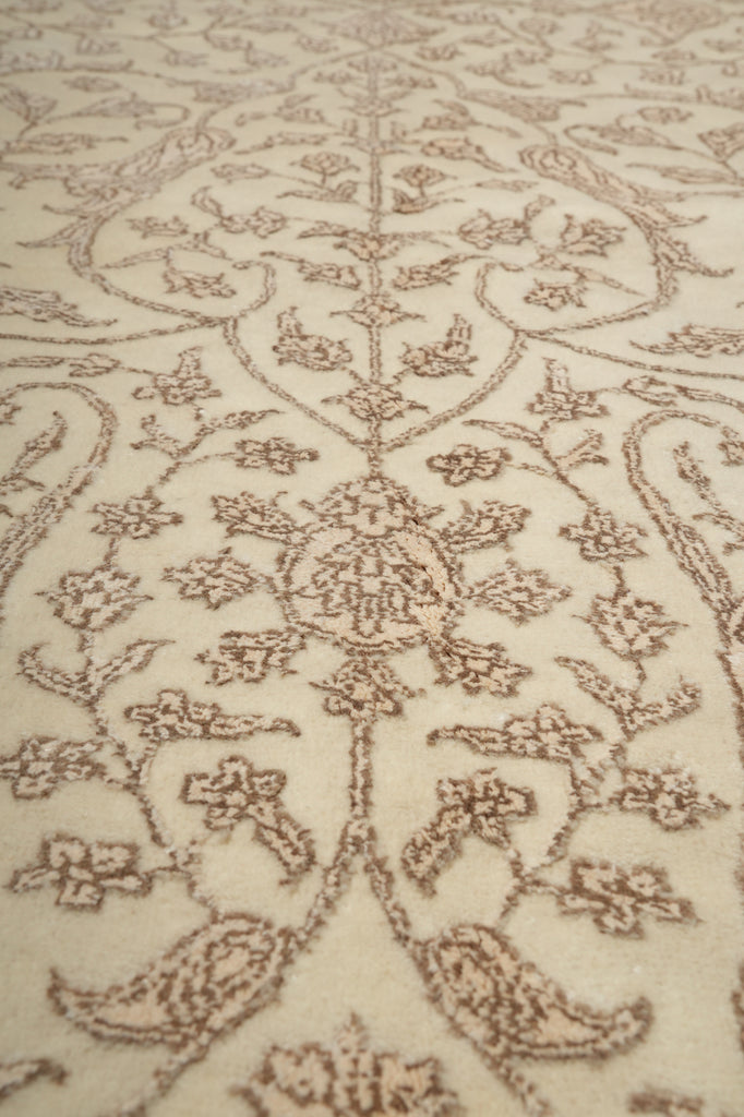 Close-up of a patterned rug with intricate designs on a beige background
