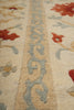 Load image into Gallery viewer, Close-up of a patterned rug with floral designs in red, blue, and beige.