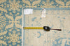 Load image into Gallery viewer, Patterned rug with a measuring tape and tags on a blue and beige floral design.