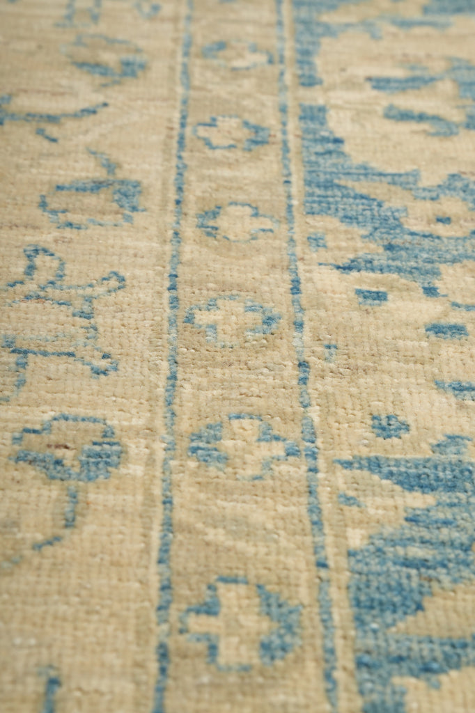 Close-up of a textured fabric with blue patterns on a beige background