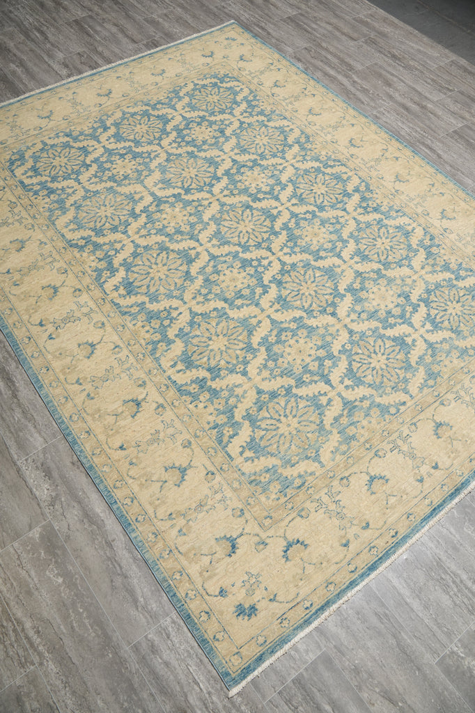 Decorative rug with blue and beige pattern on a wooden floor