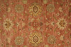 Load image into Gallery viewer, Close-up of a patterned rug with floral designs on a red-brown background
