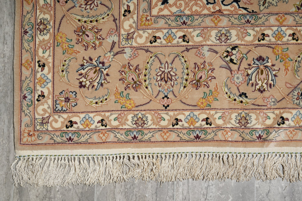Close-up of a patterned rug with intricate designs on a concrete floor.