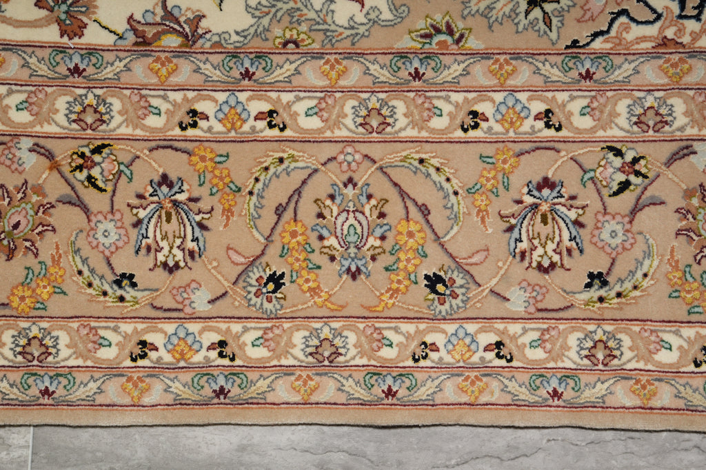 Close-up of an intricately designed rug with floral patterns on a beige background.