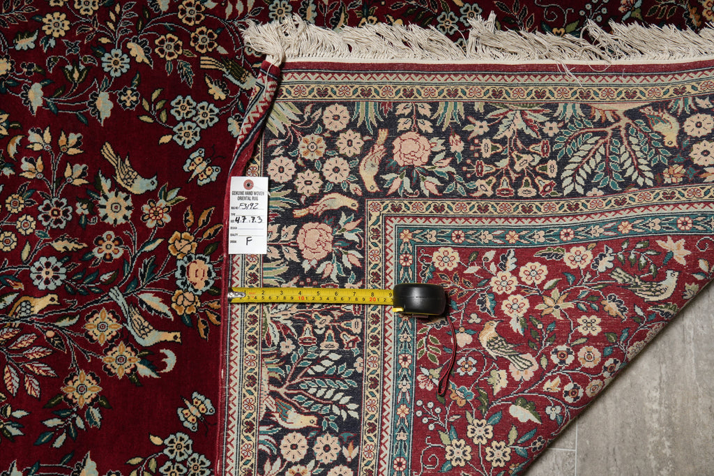 Close-up of a patterned rug with a measuring tape and label on a textured surface.