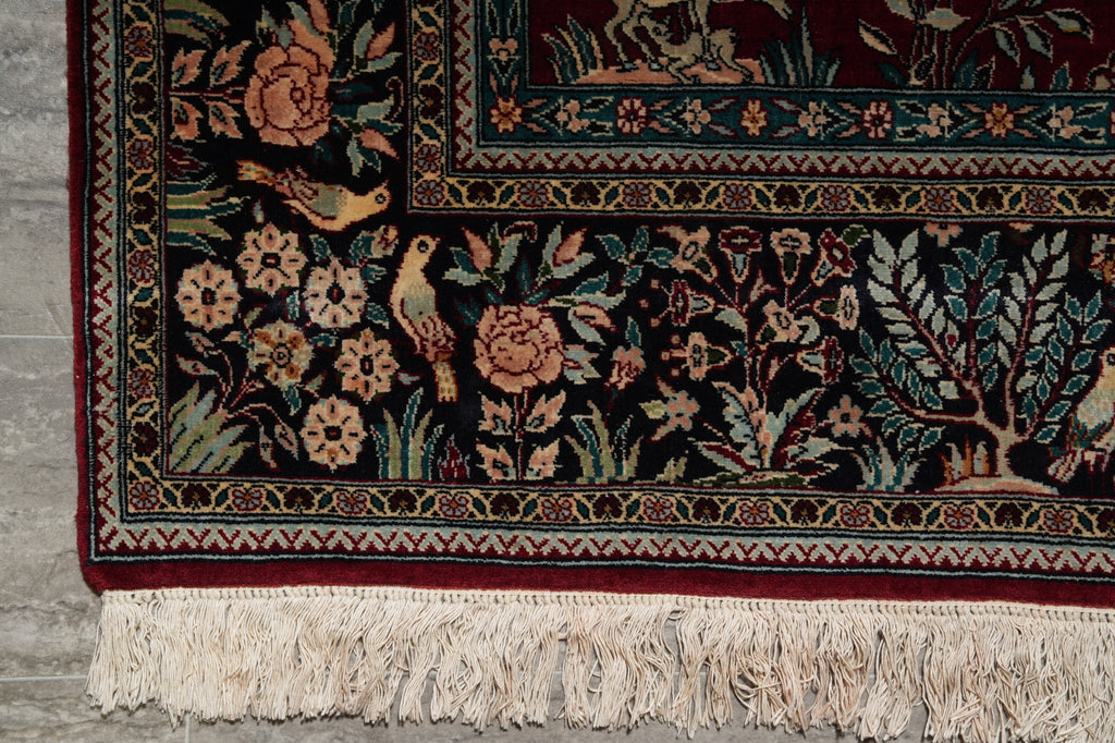 Decorative rug with floral and bird patterns on a wooden floor.