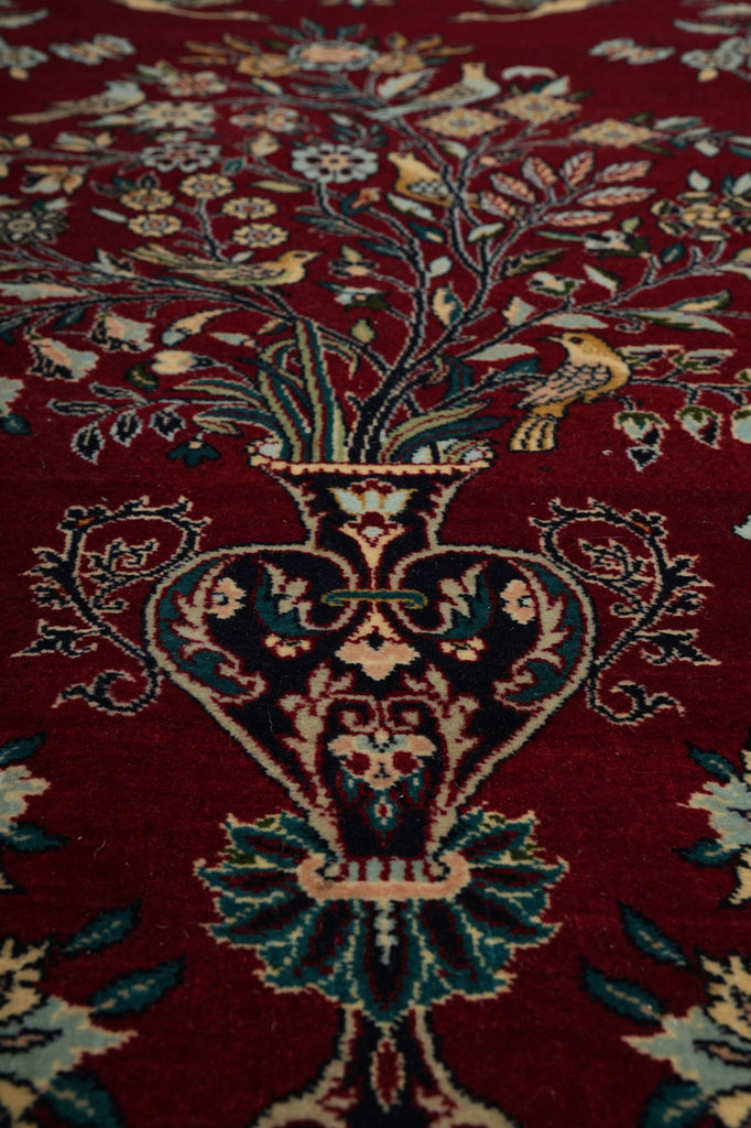 Close-up of a patterned rug with intricate designs on a red background