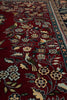 Load image into Gallery viewer, Close-up of a patterned rug with floral and bird designs on a red background.