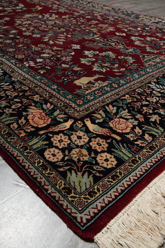 Close-up of a patterned rug with intricate designs on a white floor.